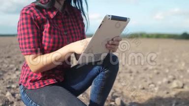 智慧生态是一种收获农业的耕作理念。 女农民用数字平板电脑研究田野里的泥土